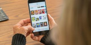 A pari of hands holds an iPhone with SimplyE on the screen