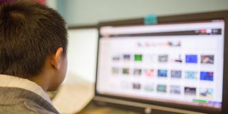 Child looks at a computer screen with various colorful rectangles displayed