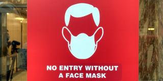 A sign in a retail window reads No Entry Without A Face Mask