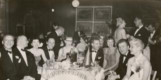 Historic photo of New Years Eve revelers sitting around a table at the Ziegfeld Theatre in New York City
