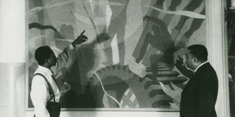 Artist Aaron Douglas (left) and Arturo Schomburg are standing in front of and looking at Douglas's painting Aspects of Negro Life: Song of the Towers. 